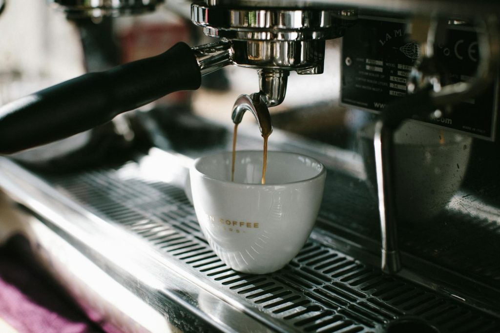 Close-up of espresso being poured into a coffee cup from a professional machine, capturing the rich coffee experience.